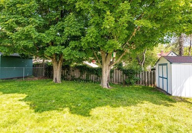 Fenced backyard featuring a shed
