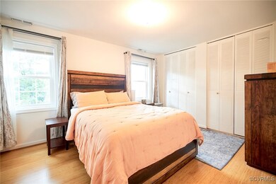 Bedroom with light wood-type flooring and two closets