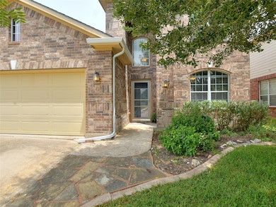 Entrance to property with brick siding and an att