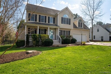 View of front facade featuring covered porch, a front lawn, and a garage
