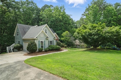 View of front facade featuring driveway, a front lawn, and a shingled roof