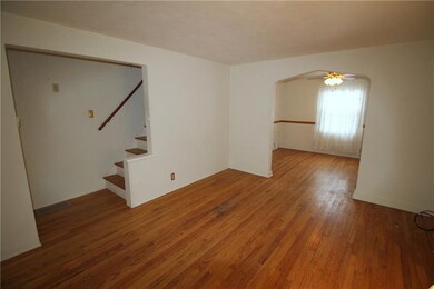 The living room features hardwood flooring and neu