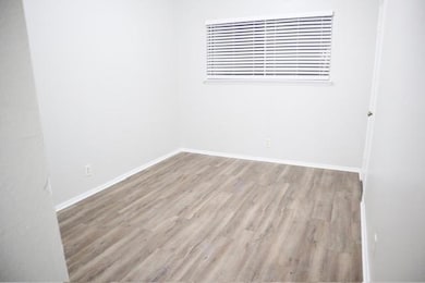 Empty room with baseboards and wood finished floo