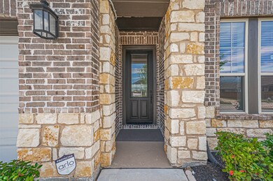 The entryway features a charming brick and stone f