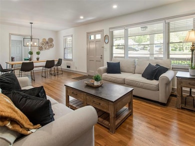 Living area with light wood-style floors, a chandelier, recessed lighting, and baseboards