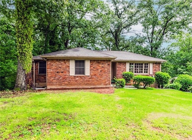 Ranch-style home with a front yard and brick siding