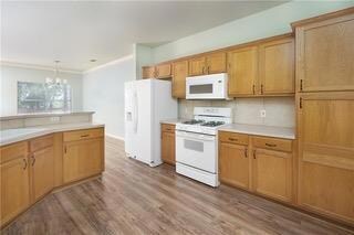 Kitchen featuring white appliances, a chandelier,