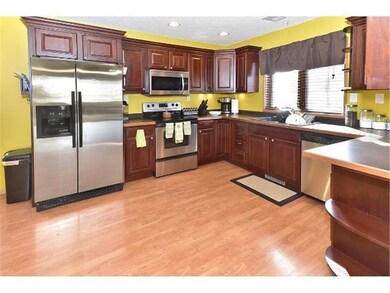 Stainless steel appliances and cherry cabinets mak