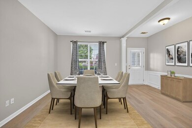 Virtually Staged Dining space with light wood-style floors, wainscoting, and decorative columns