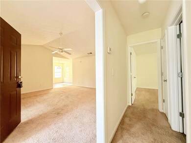 Hallway featuring light carpet, visible vents, bas