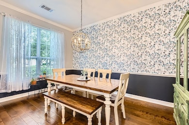 Dining space with wallpapered walls, a wainscoted