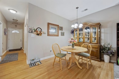 Dining space with a chandelier, light wood-type flooring, and baseboards