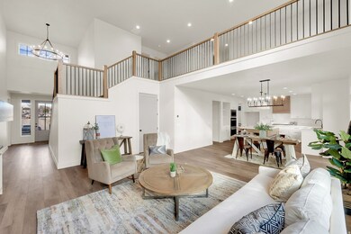 Living room featuring a chandelier, a towering ceiling, light wood-style floors, and recessed lighting