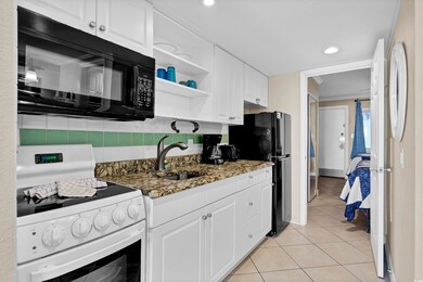 Kitchen with black appliances, dark stone counters