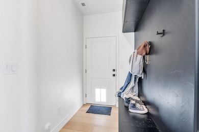 Doorway with baseboards and wood finished floors