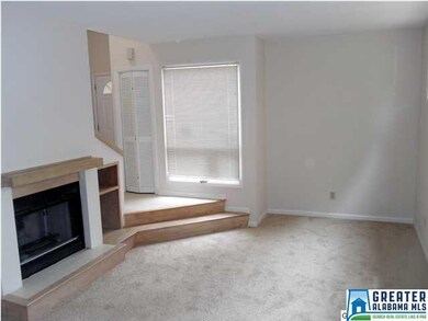 Sunken living room has a wood-burning fireplace wi