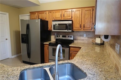 Kitchen with granite countertops and tile backspla