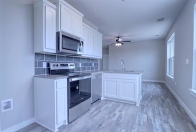 Kitchen featuring kitchen peninsula, light hardwoo