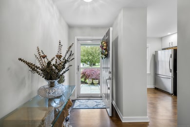 Front foyer opens to light-filled interior spaces with hardwood flooring throughout main level.