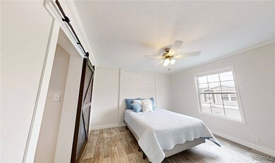 Bedroom with a barn door, light wood-type flooring