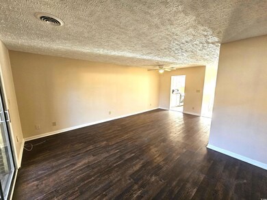 Unfurnished room featuring ceiling fan, dark wood-
