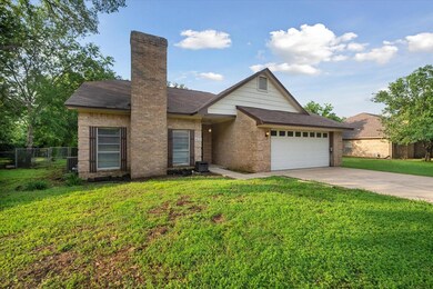 View of front of home featuring a garage, central AC unit, and a front lawn