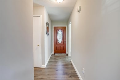 Doorway to outside featuring baseboards and wood finished floors