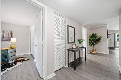 Corridor with wood finished floors, a textured ceiling, and baseboards