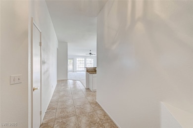 Hallway with light tile patterned floors and baseb