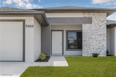 View of exterior entry featuring a garage, stucco