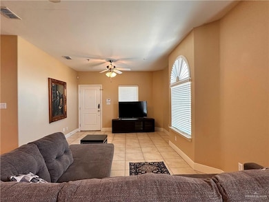 Living room with light tile patterned floors and a ceiling fan