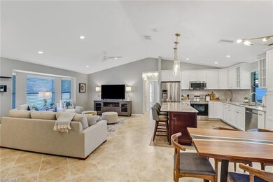 Living room featuring ceiling fan, lofted ceiling, plenty of natural light, light tile patterned flooring, and recessed lighting