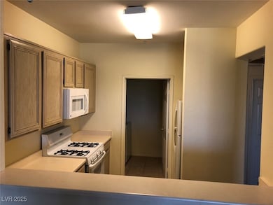 Kitchen featuring white appliances, light countert