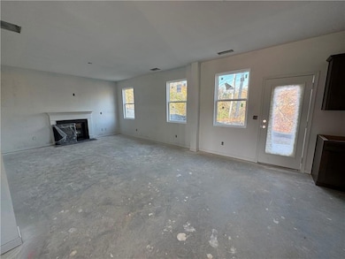 Unfurnished living room featuring a fireplace with flush hearth