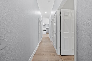 Corridor with recessed lighting, a textured wall,