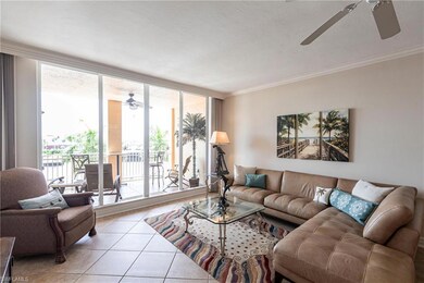 Tiled living area with ceiling fan, ornamental molding, expansive windows, and a textured ceiling