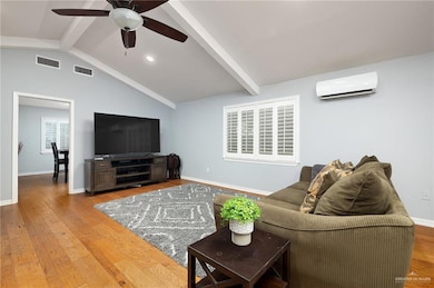 Living room with an AC wall unit, ceiling fan, wood finished floors, and recessed lighting