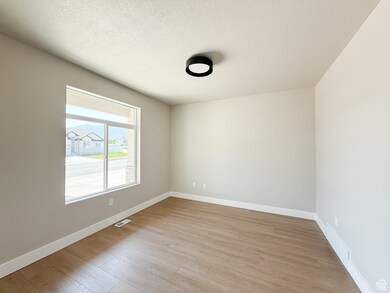 Spare room with a textured ceiling and light wood-type flooring