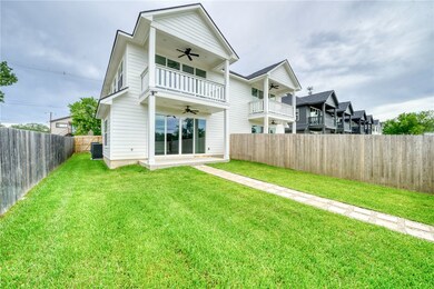 Back of house featuring a ceiling fan, a fenced ba