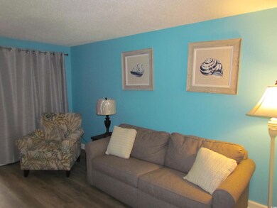 Living area featuring wood finished floors and a textured ceiling