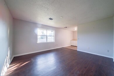 Empty room featuring a textured ceiling and wood-t