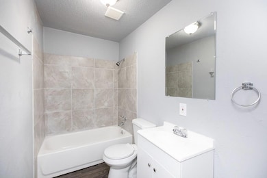 Bathroom with a textured ceiling, toilet, visible