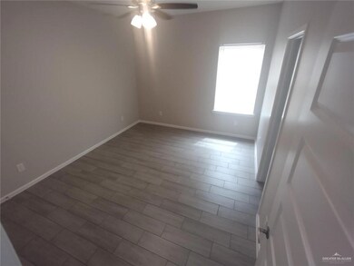 Unfurnished room featuring a ceiling fan and baseboards