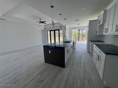 Kitchen featuring an island with sink, a raised ce