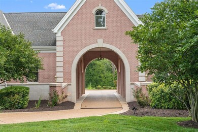 A porte cochere leads to an auto court and 2 garag