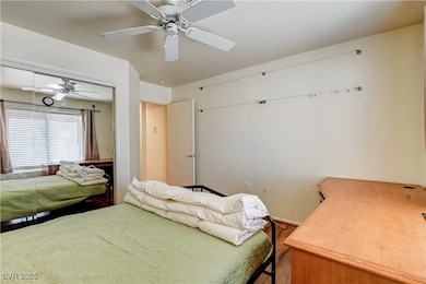 Bedroom featuring a ceiling fan, wood finished flo