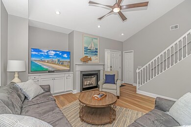 Living room featuring high vaulted ceiling, light wood-type flooring, and ceiling fan