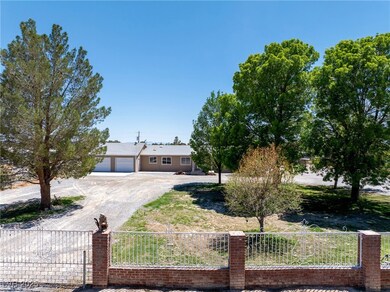 Ranch-style home with a fenced front yard and dirt