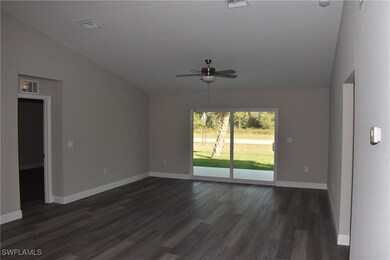Spare room with dark wood finished floors, visible vents, and baseboards