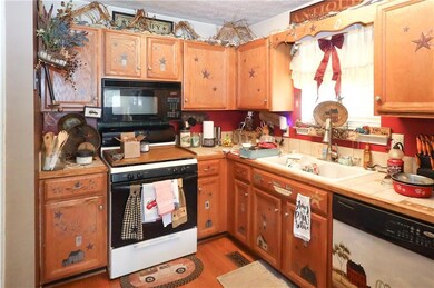 Kitchen featuring light wood-type flooring, white appliances, a textured ceiling, a sink, and tile countertops